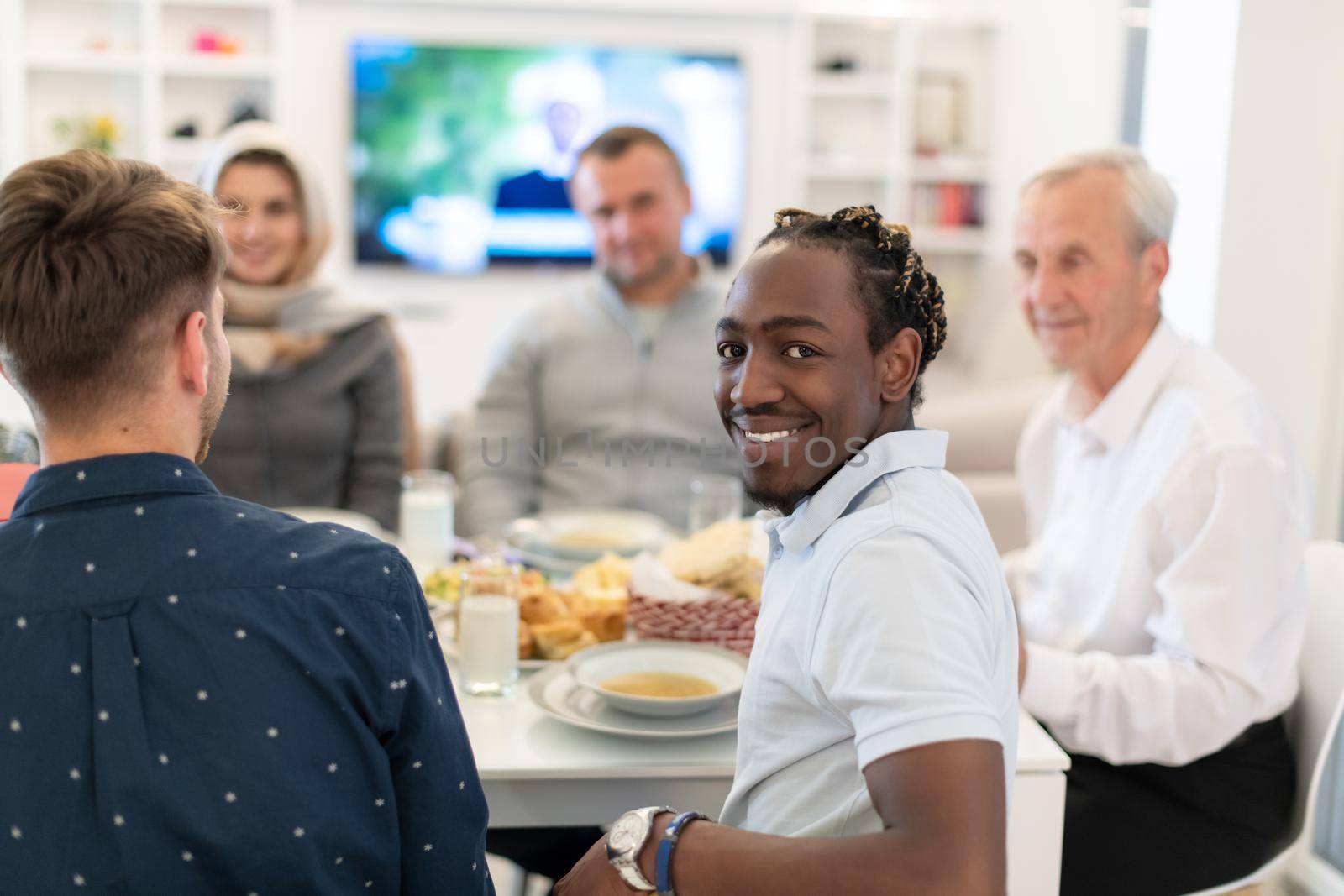 black man enjoying iftar dinner with family by dotshock