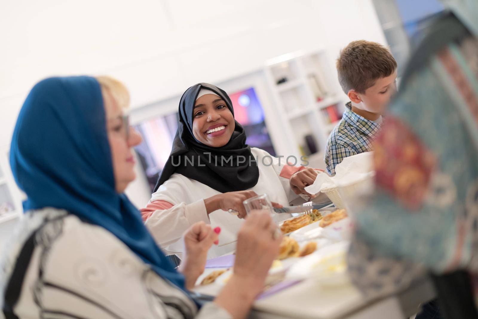 black modern muslim woman enjoying iftar dinner with family by dotshock