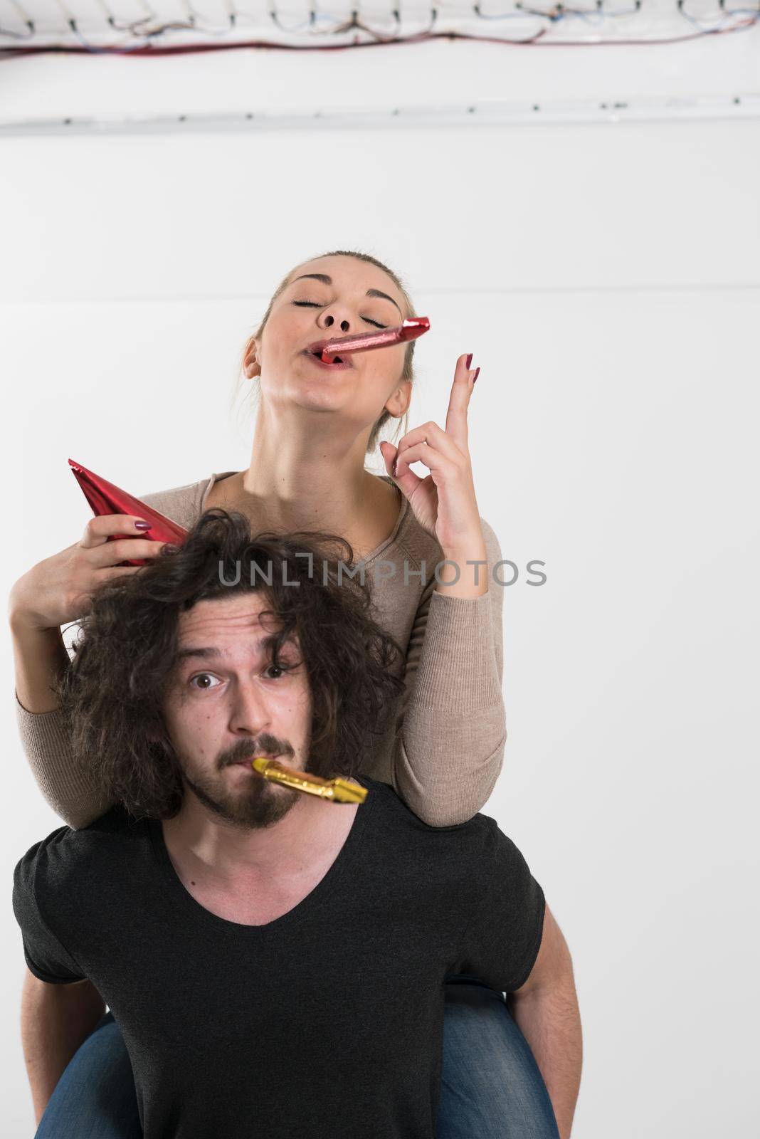 happy young romantic  couple in love  celebrating and blowing confetti decorations at new year and charismas  party