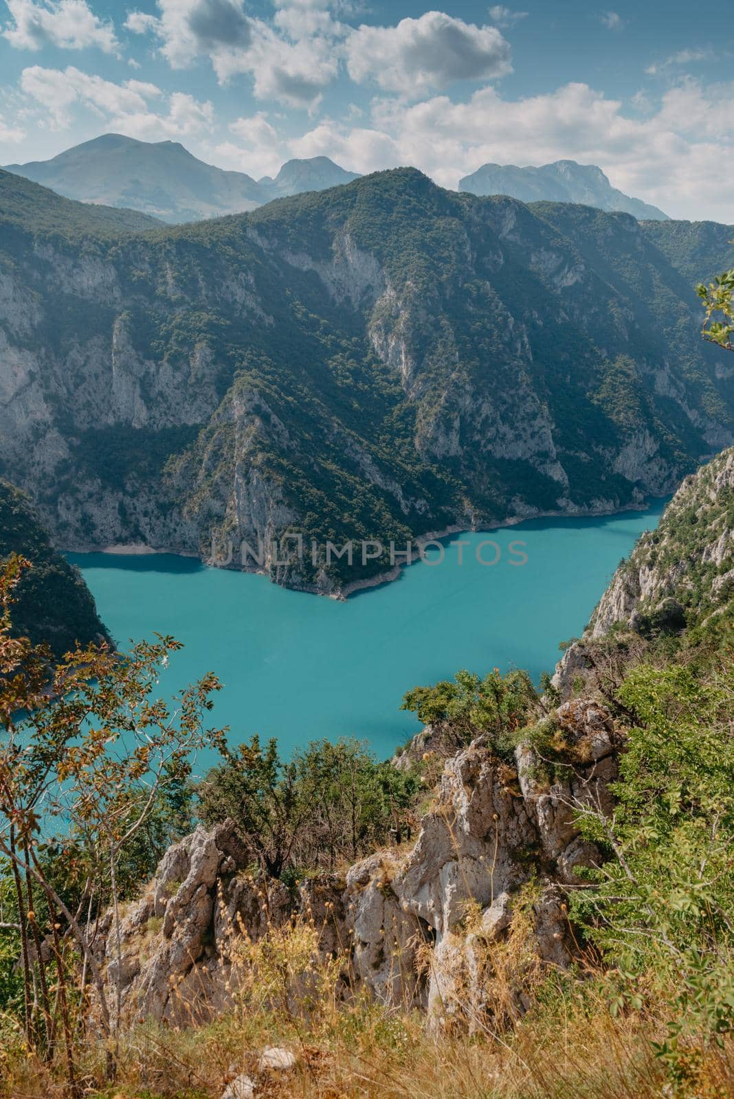 The concept of eco-tourism and active recreation. National Park. Mountain Emerald lake in the wooded mountains. Sunny day in autumn by Andrii_Ko