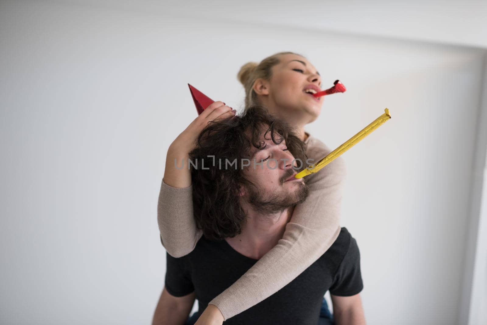 happy young romantic  couple in love  celebrating and blowing confetti decorations at new year and charismas  party