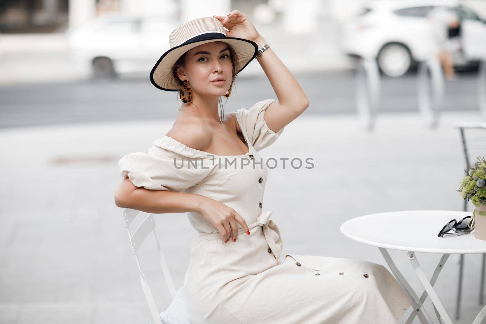 Fashion young woman in sunglasses with hat in street cafe with coffee. High quality photo