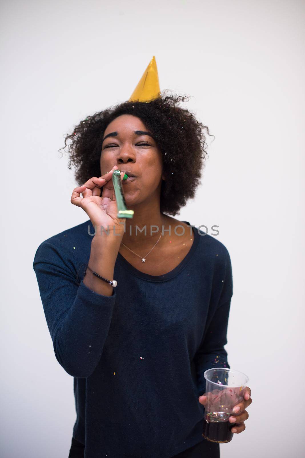 happy young woman celebrating new years eve party while blowing confetti