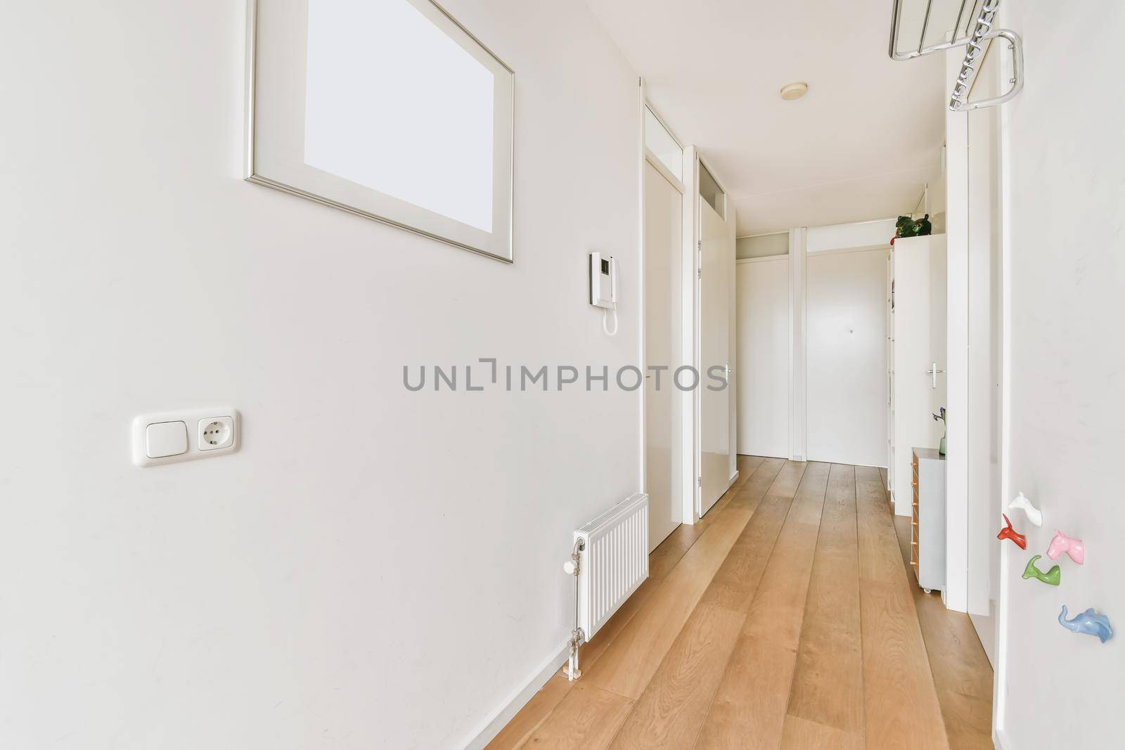 Stylish long light corridor with hanger and painting