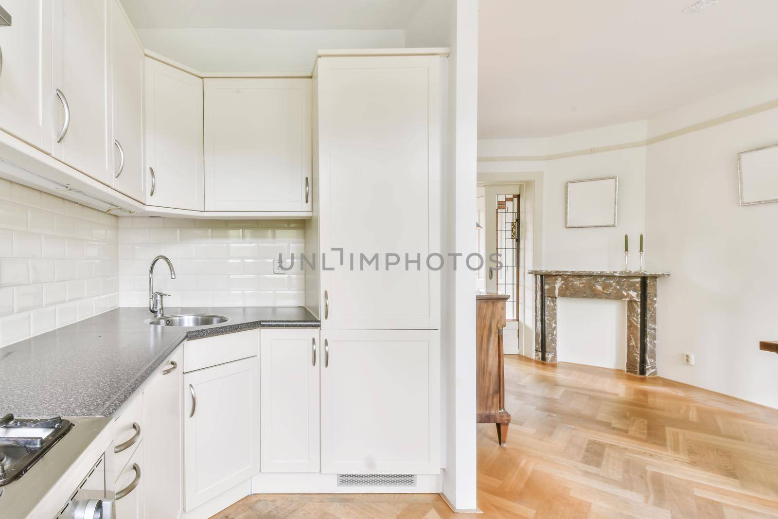Interior of spacious light kitchen with modern white furniture in light apartment