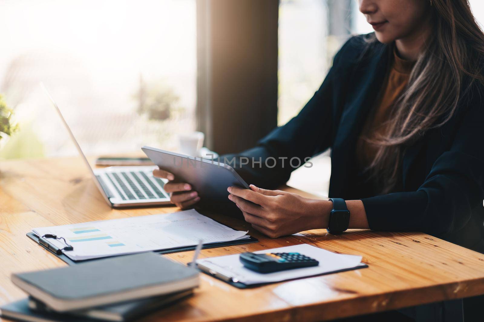 Asian businesswoman investment consultant analyzing company annual financial report balance sheet statement working with documents graphs. Concept picture of business, market, office, tax.