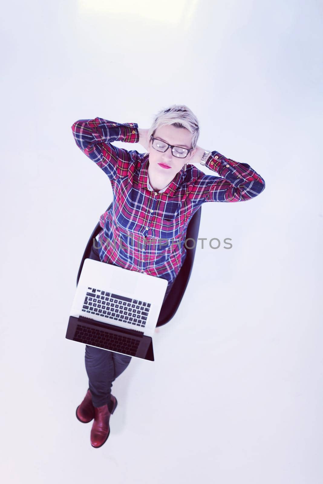 top view of young business woman working on laptop computer in modern bright startup office interior, sitting on floor