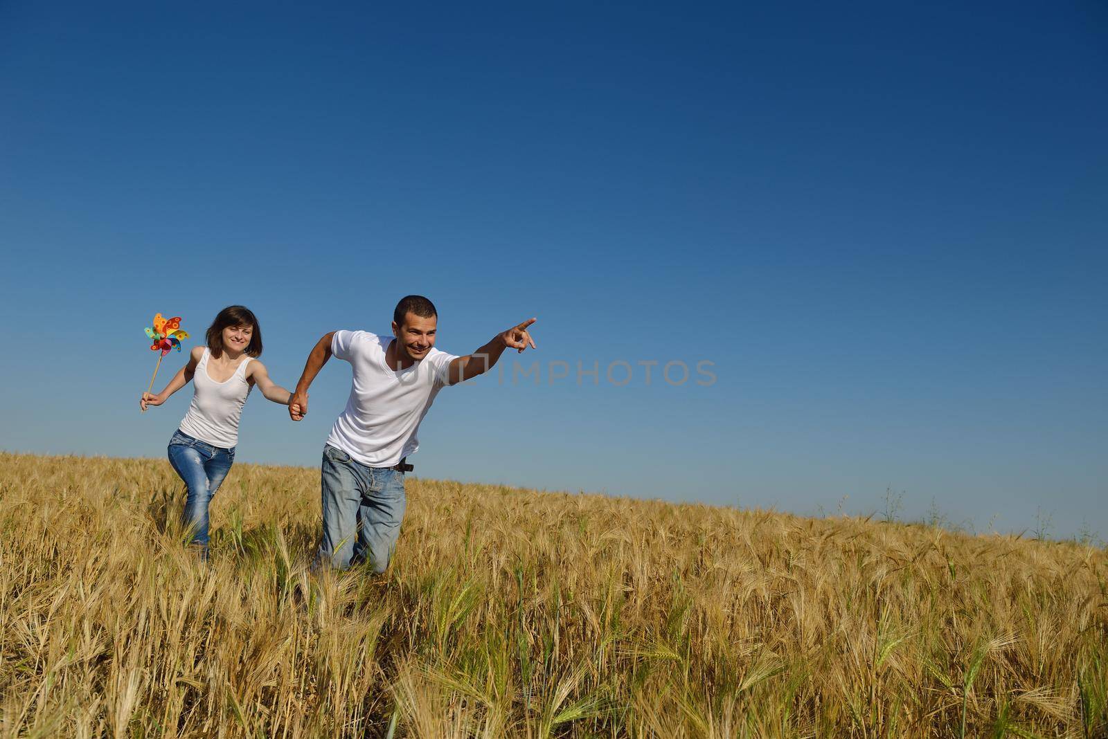 happy young couple in love have romance and fun at wheat field in summer