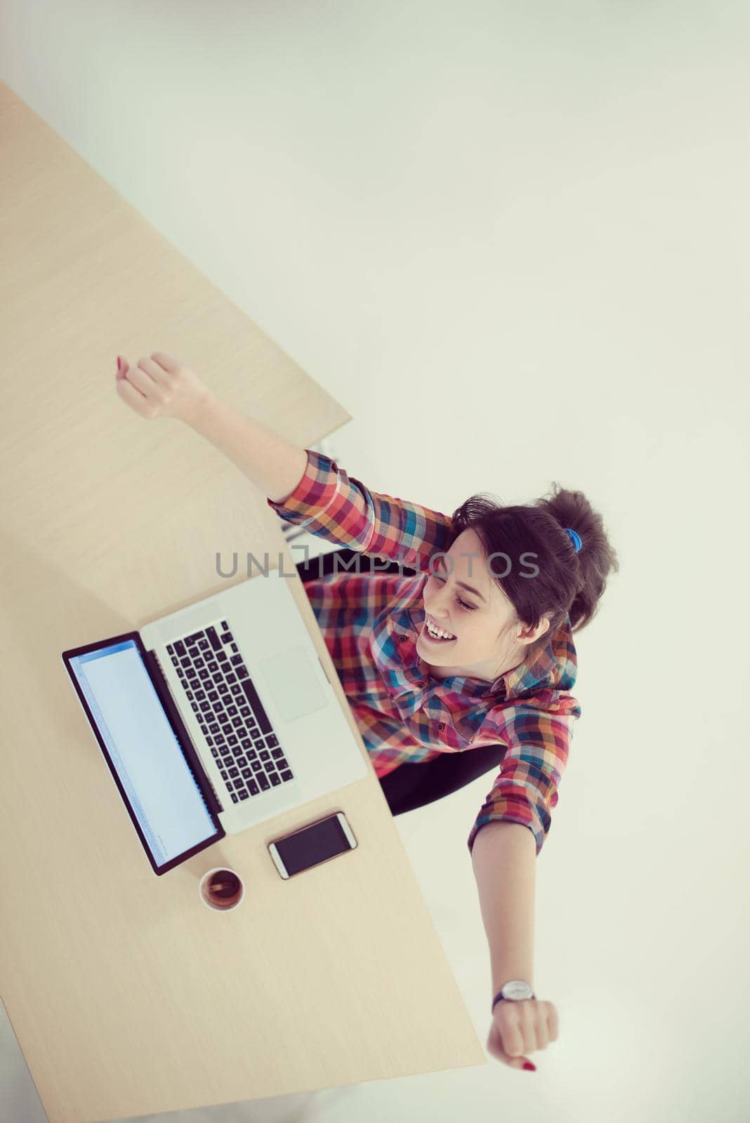 top view of young business woman working on laptop computer in modern bright startup office interior