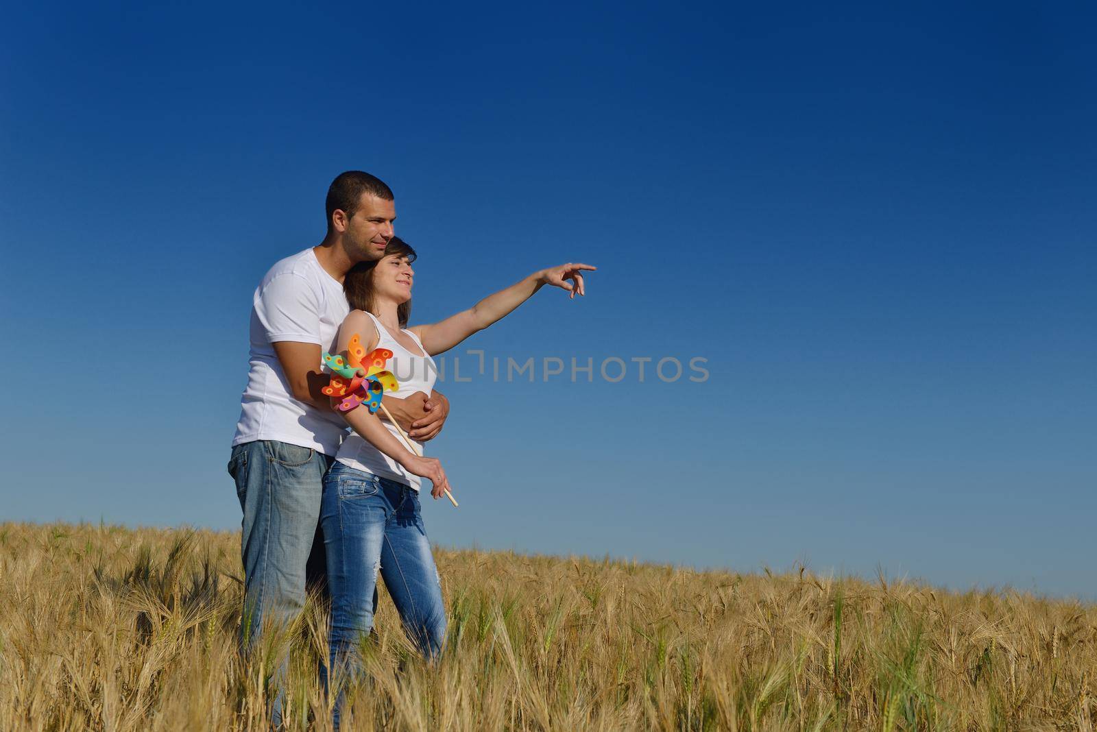 happy couple in wheat field by dotshock