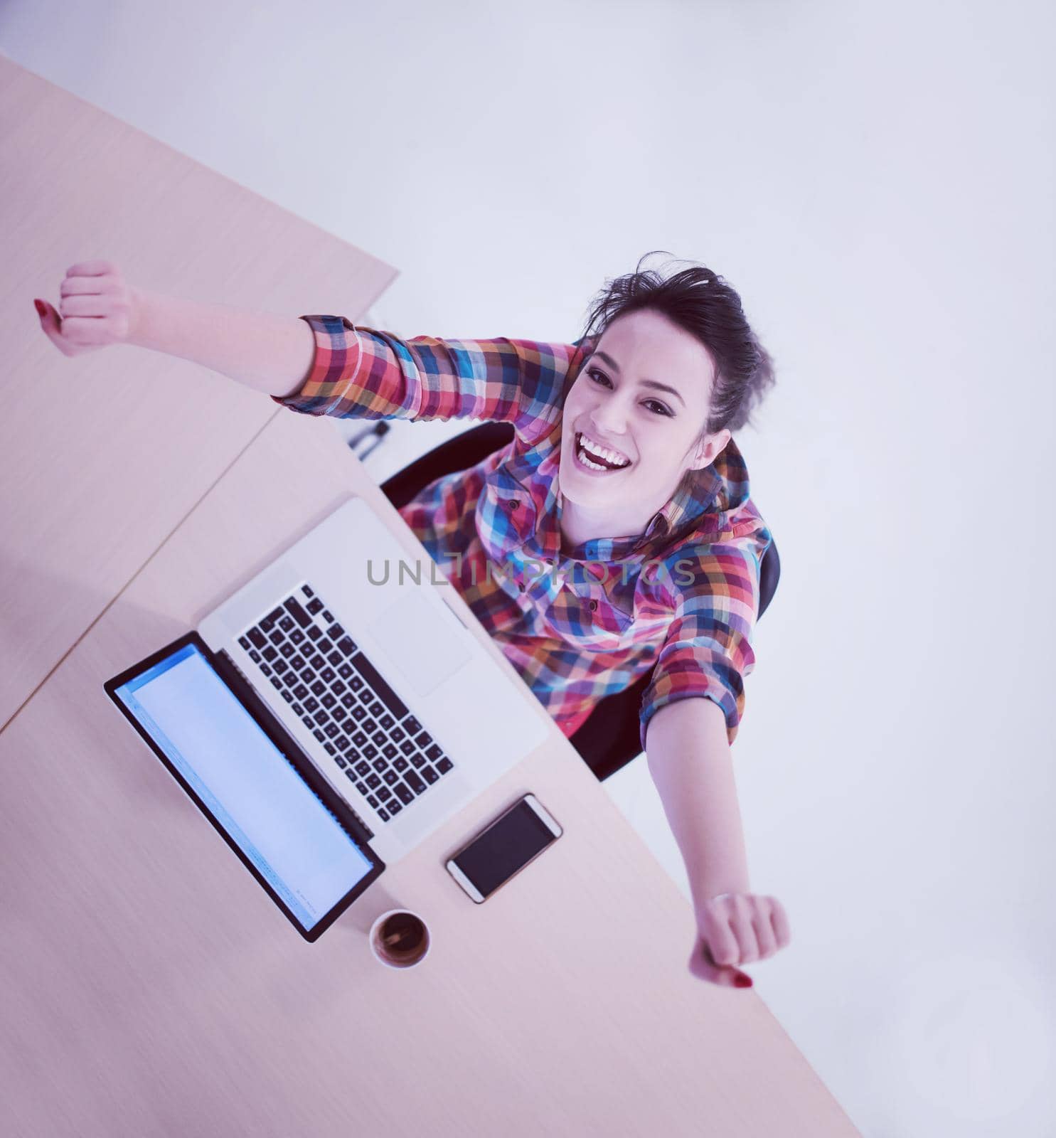 top view of young business woman working on laptop computer in modern bright startup office interior