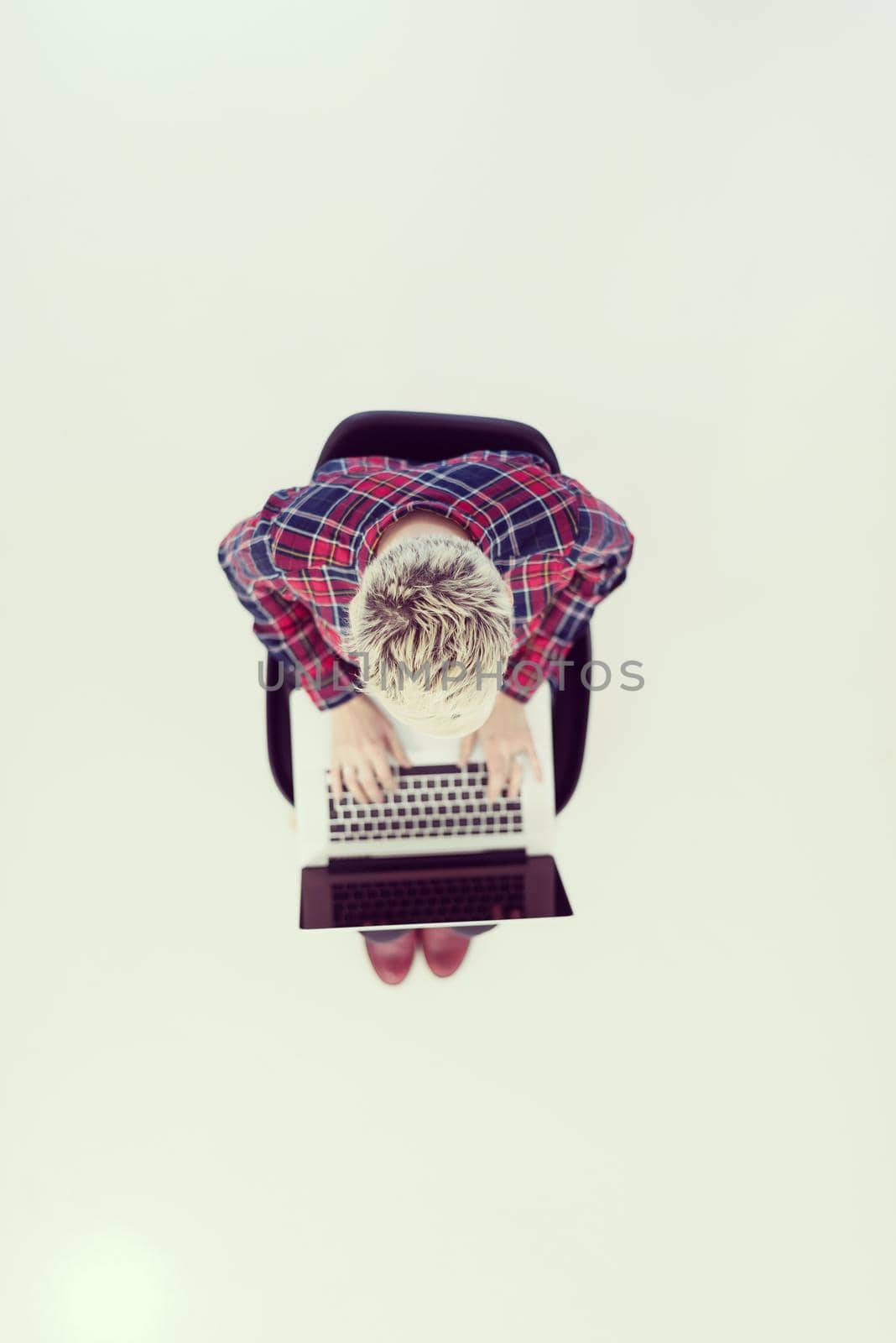 top view of young business woman working on laptop computer in modern bright startup office interior, sitting on floor