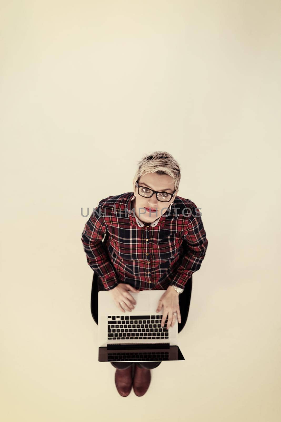 top view of young business woman working on laptop computer in modern bright startup office interior, sitting on floor