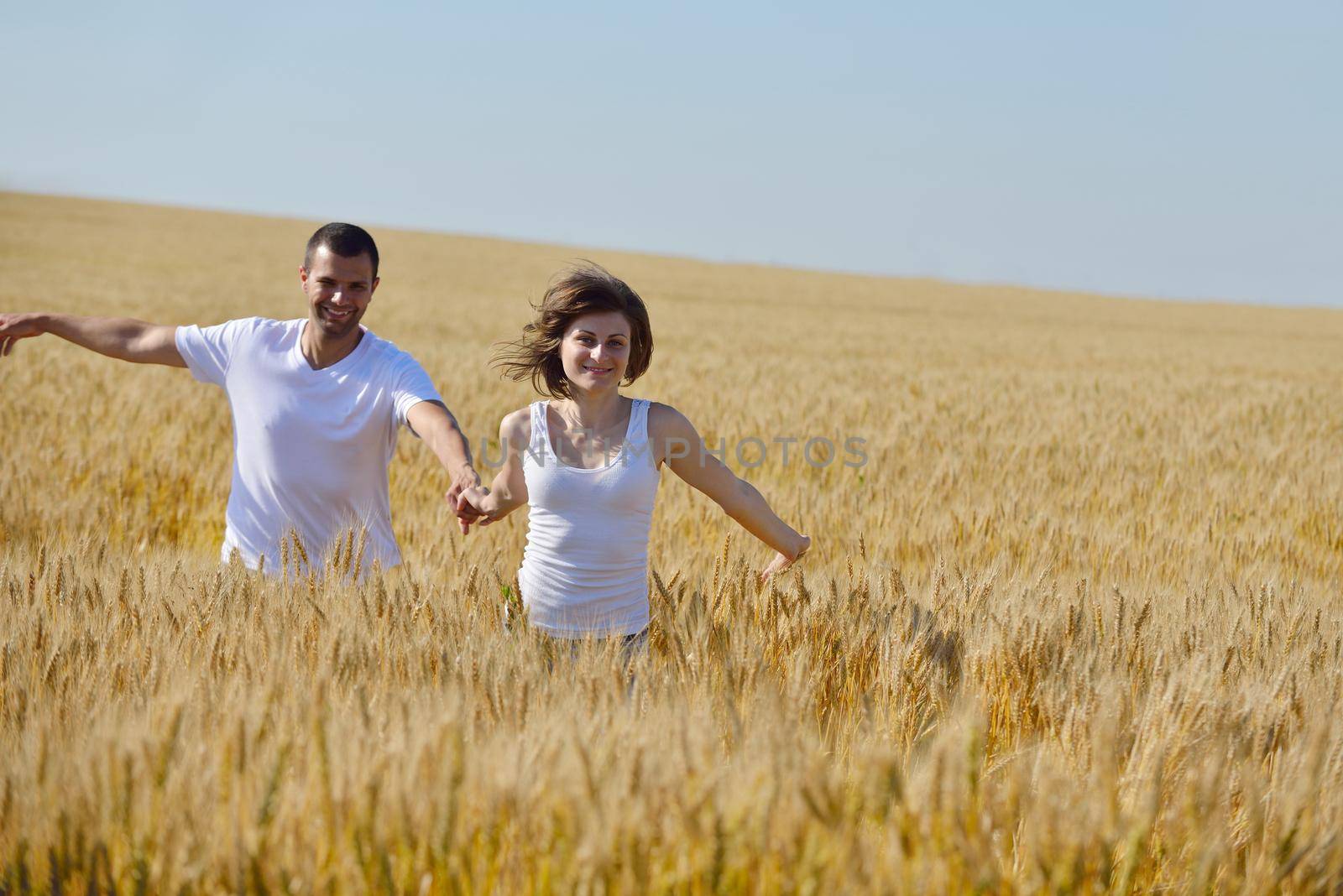 happy couple in wheat field by dotshock