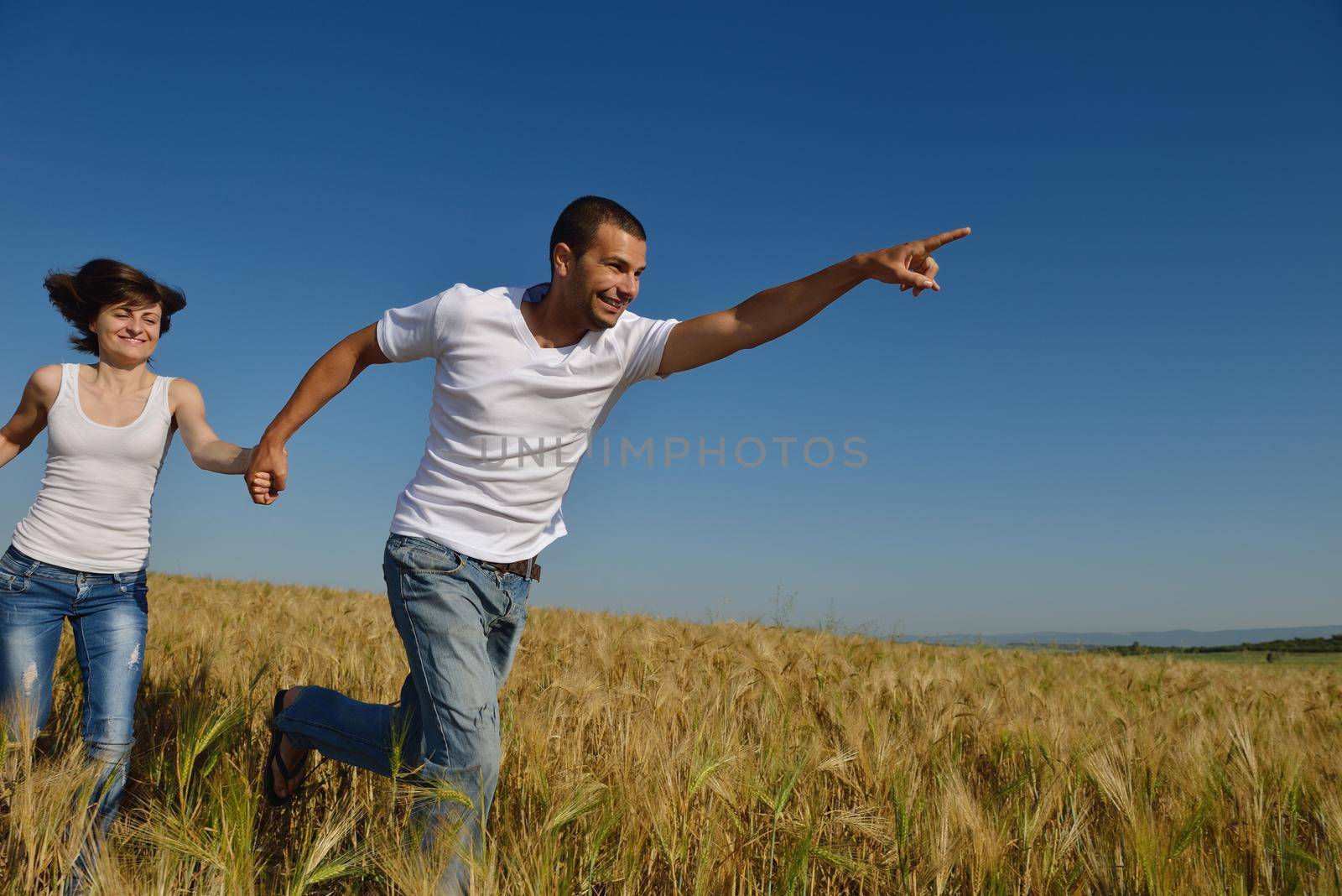 happy young couple in love have romance and fun at wheat field in summer