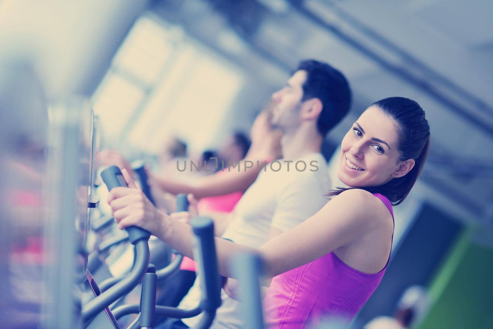 Group of people running on treadmills by dotshock