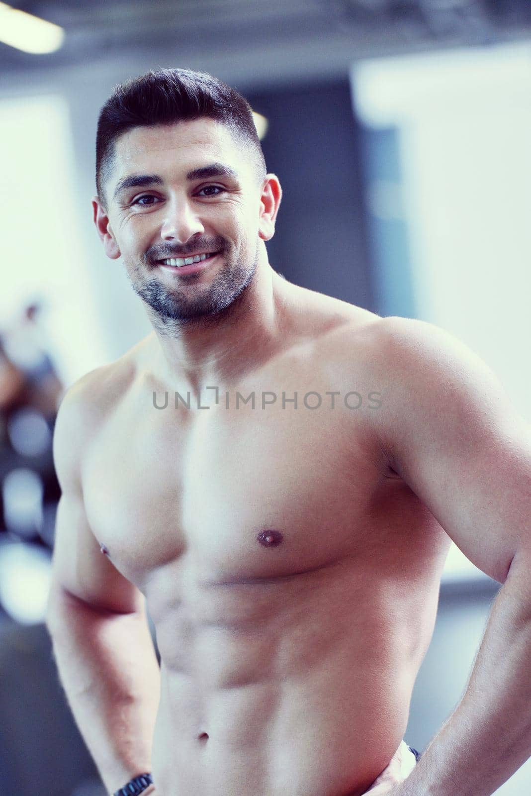 Strong handsome man exercising at the gym