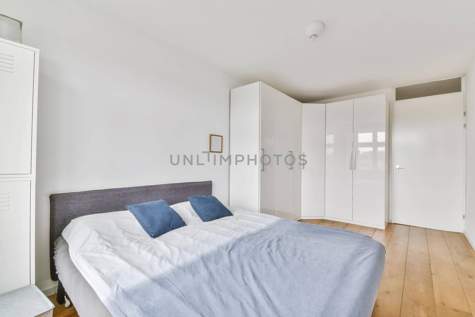 Stylish bedroom with a beautifully laid bed and a large white wardrobe