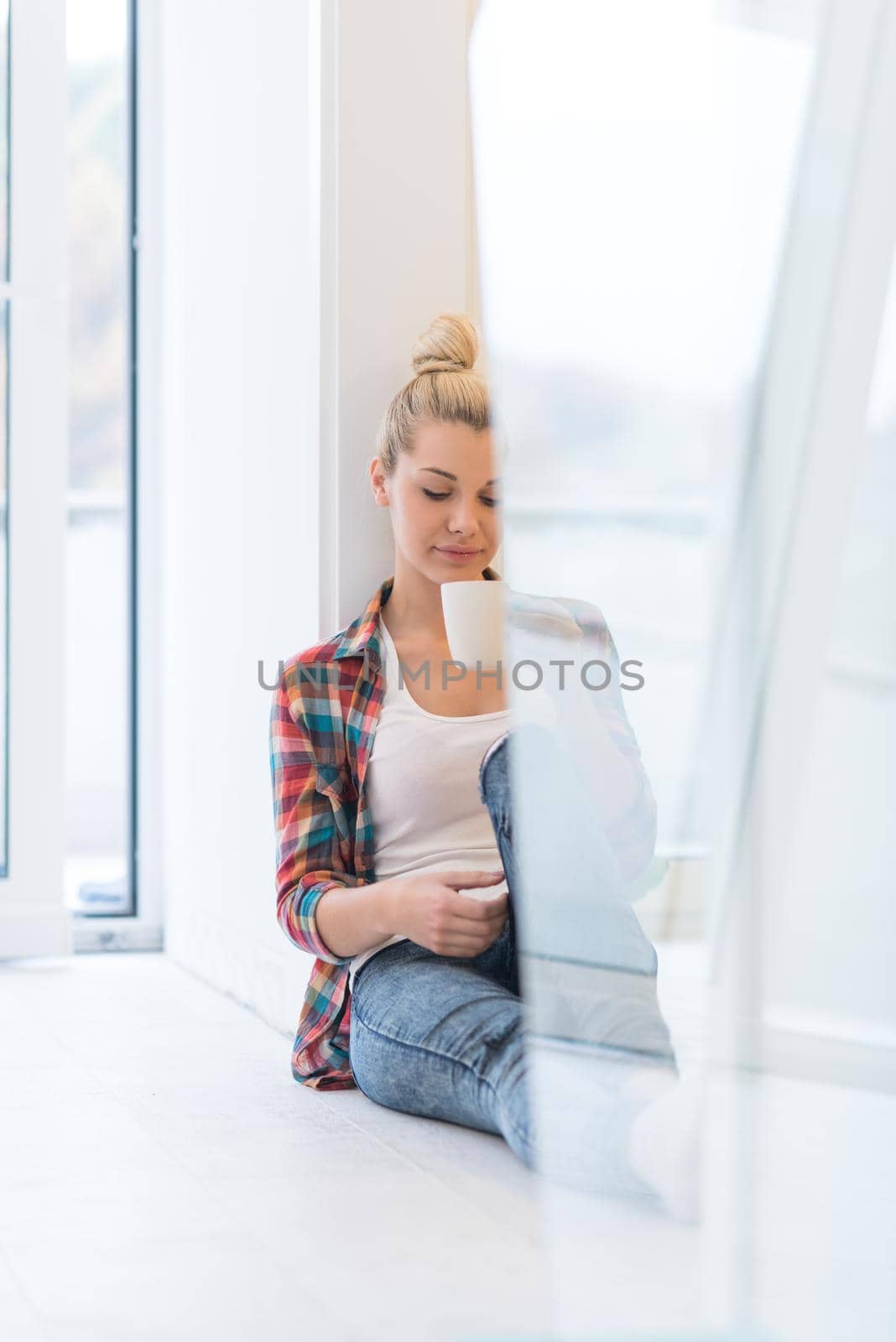 Portrait of a beautiful girl who is sitting on the floor and drinking coffee