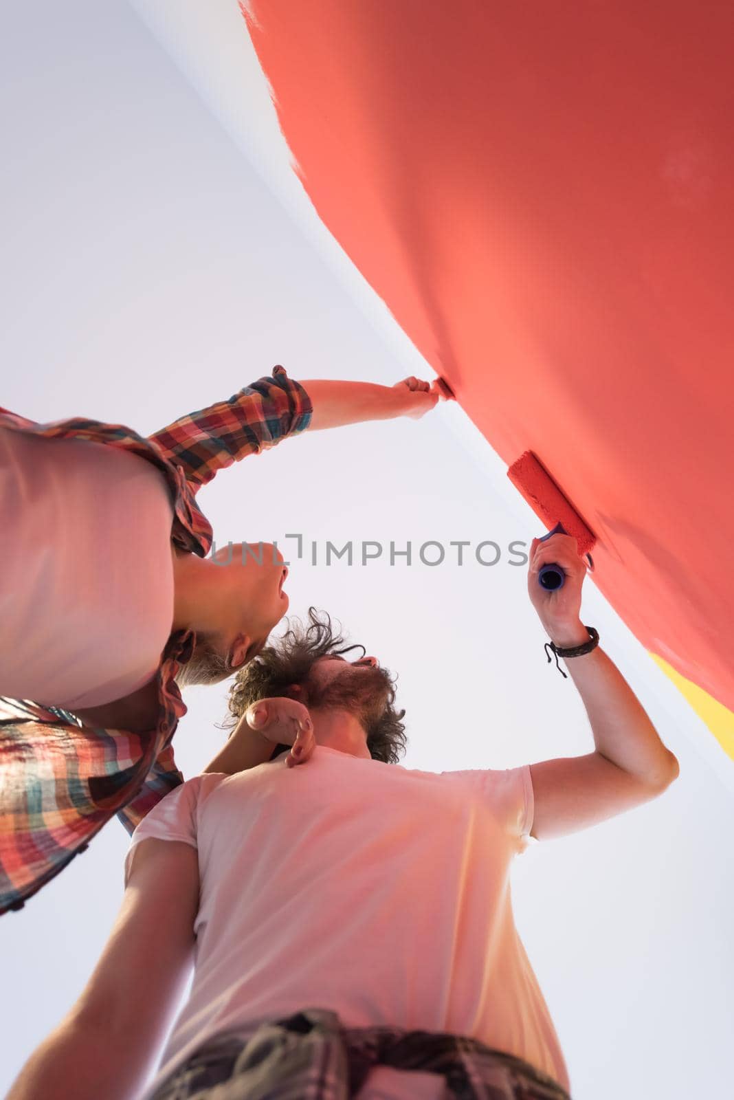 couple painting interior wall by dotshock