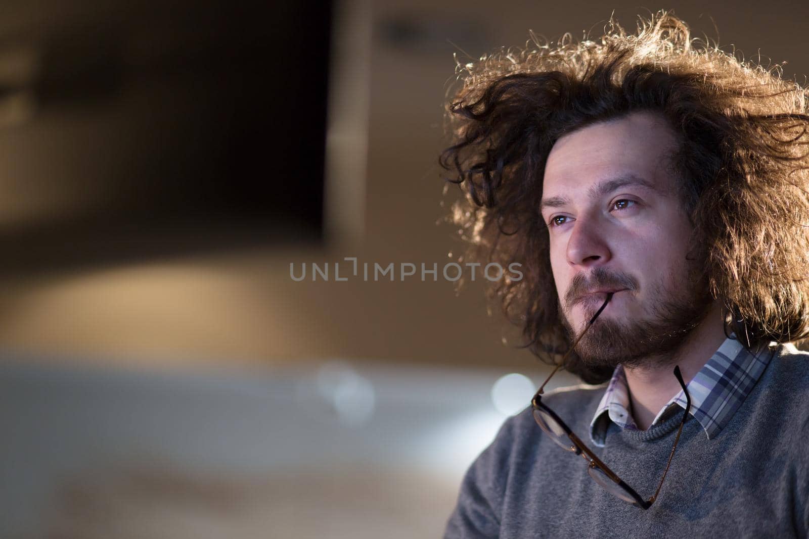 man working on computer in dark office by dotshock