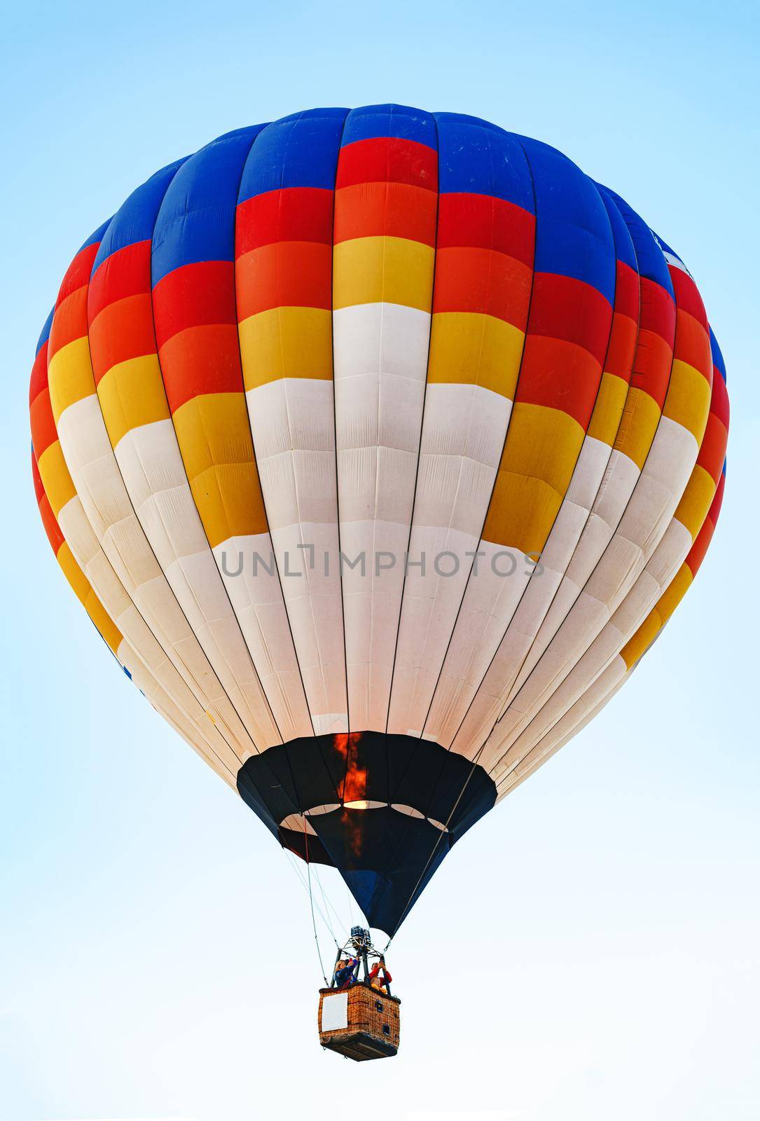 Multicolored air balloon in clear blue sky close up