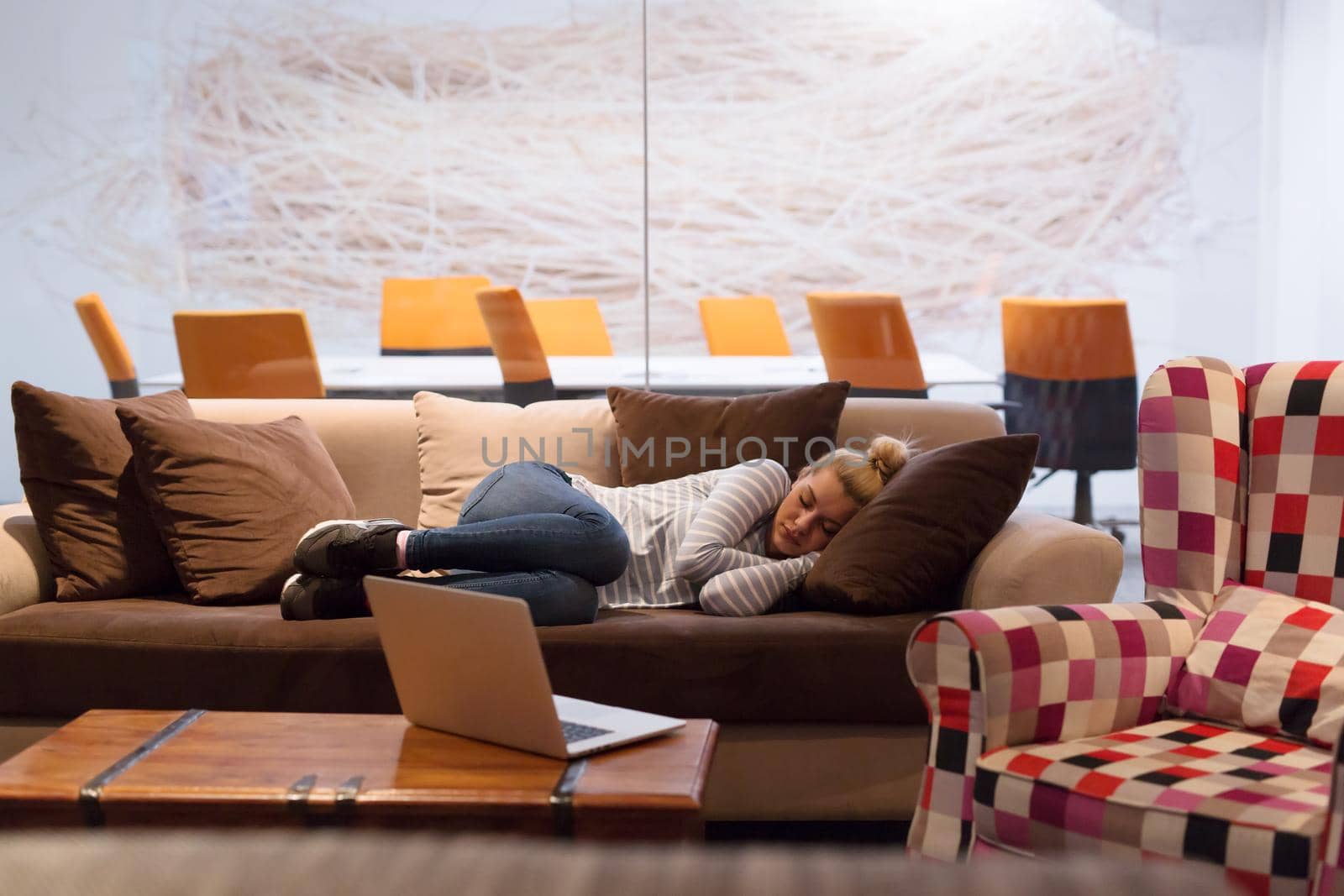 woman sleeping on a sofa  in a creative office by dotshock