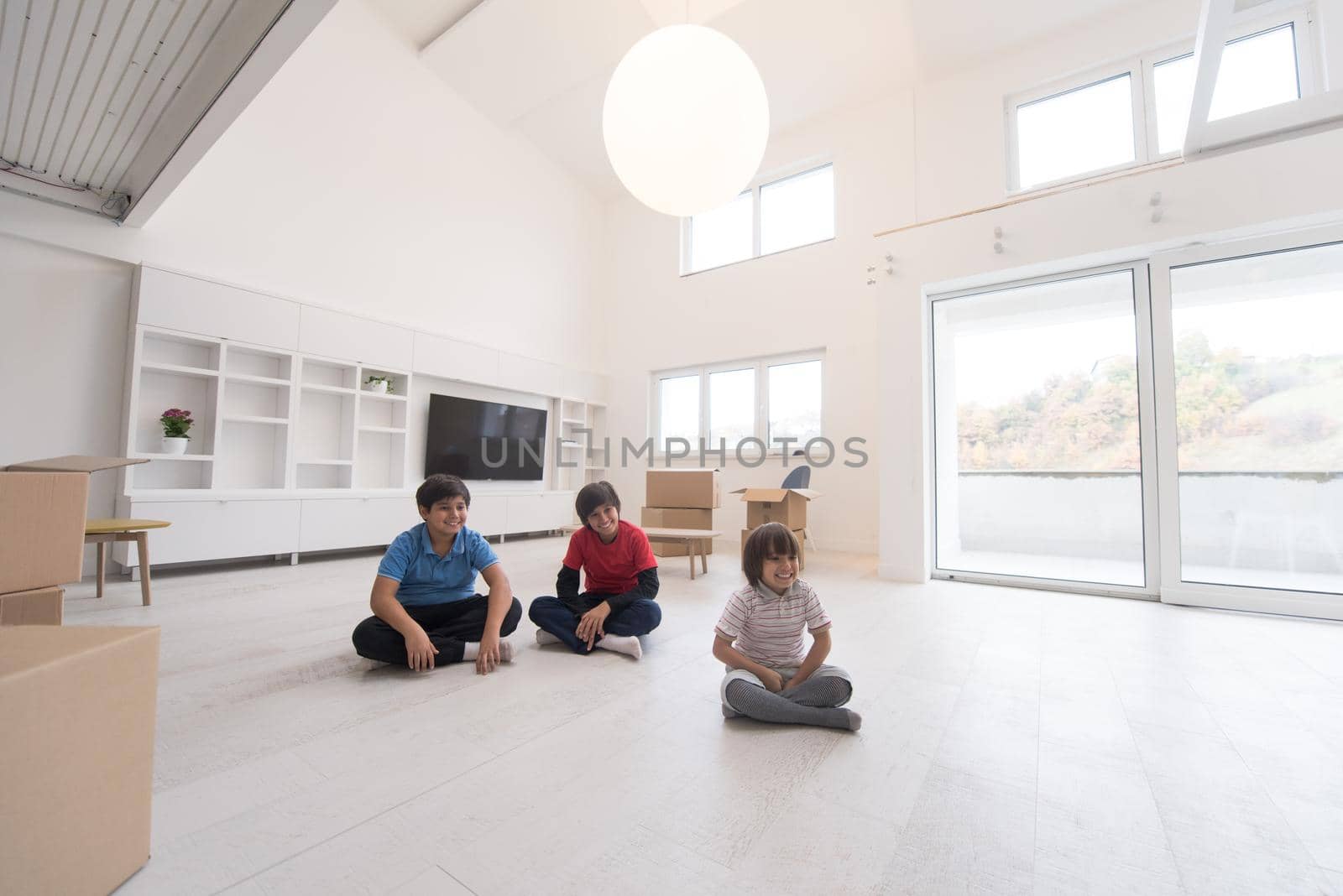 happy young boys having fun on the floor in a new modern home