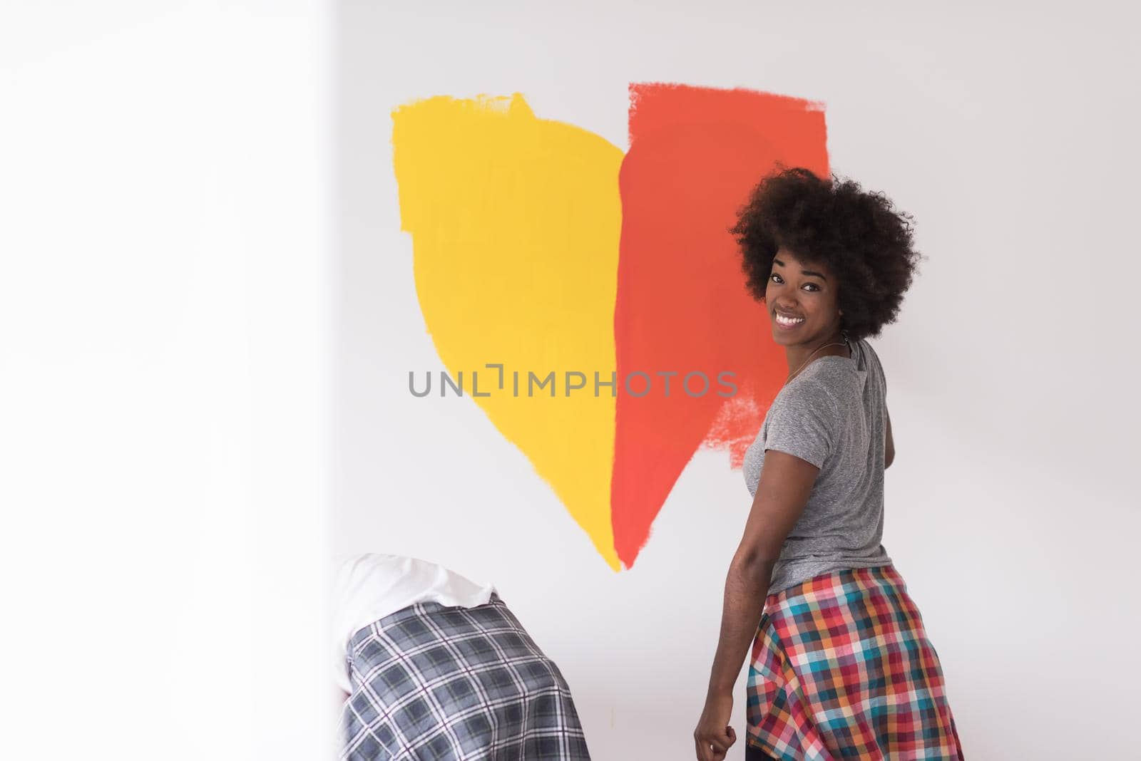 multiethnic couple painting interior wall by dotshock