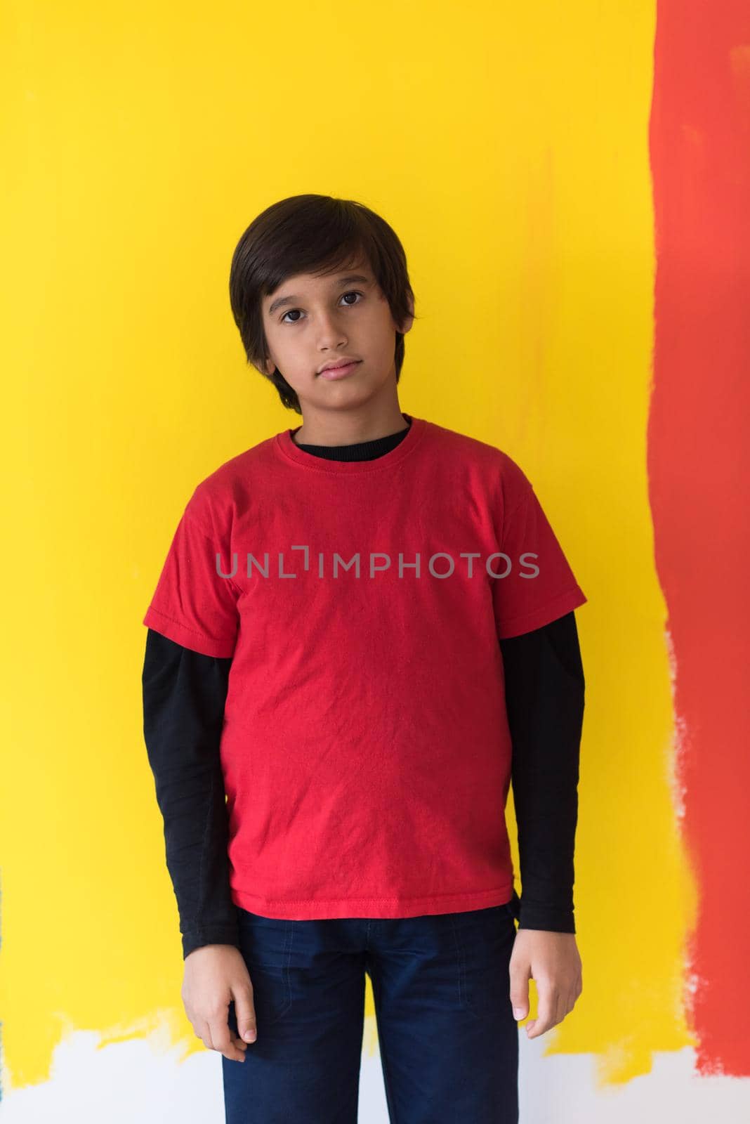 Portrait of a happy young boy in front of colored background