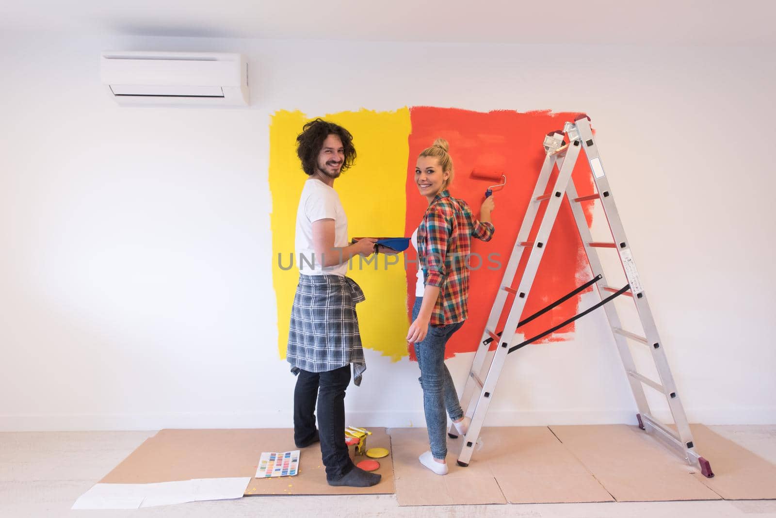 couple painting interior wall by dotshock