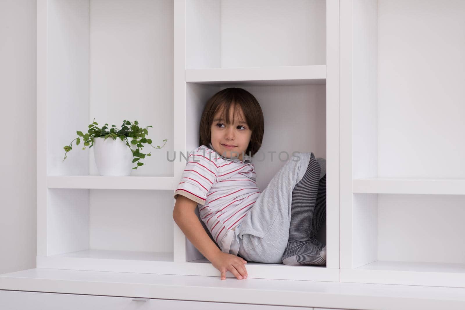 young boy posing on a shelf by dotshock