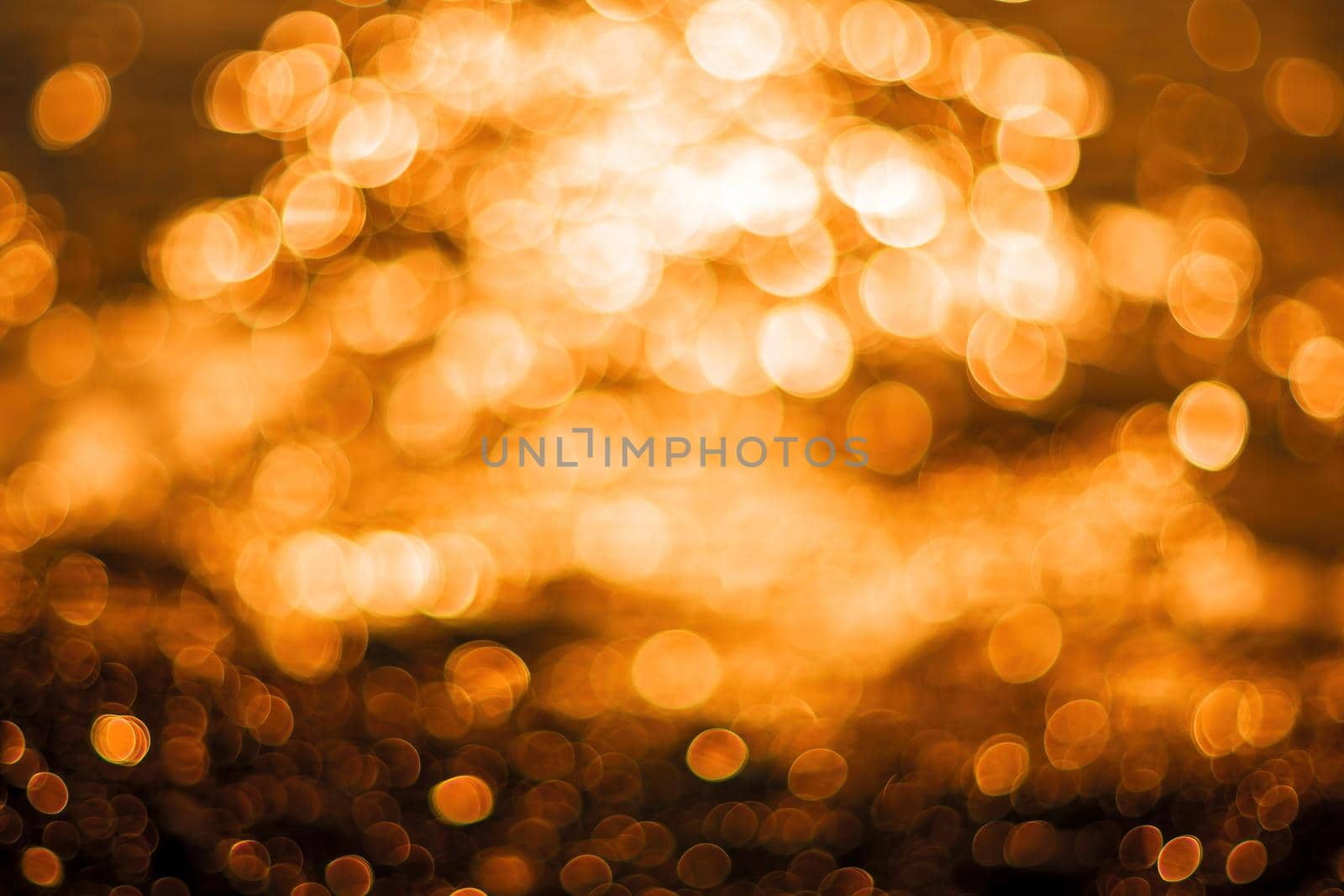 Abstract nature summer or spring ocean sea background. Small waves on water surface in motion blur with bokeh lights from sunrise.