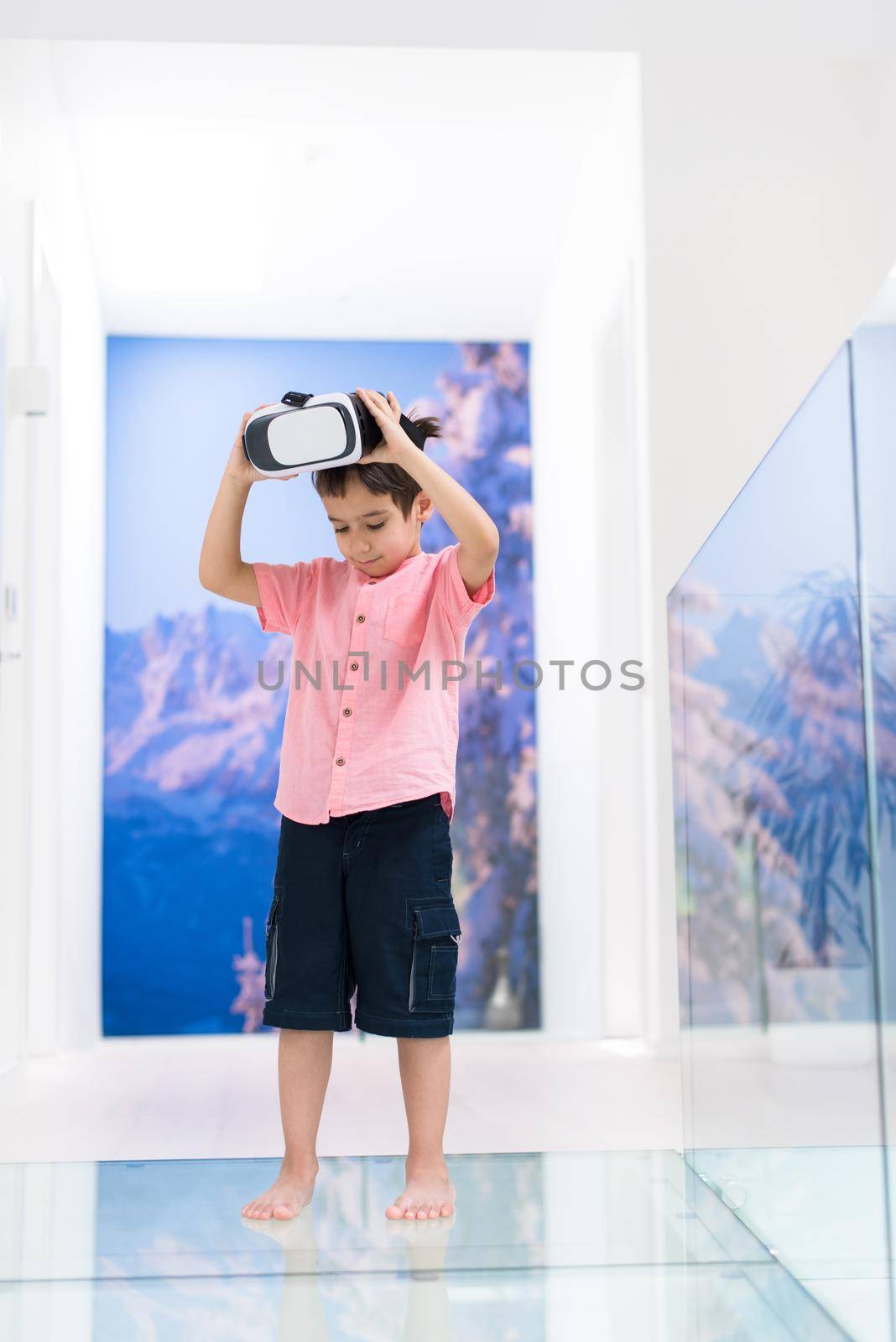 kid at home wearing vr glasses putting hands up and playing games