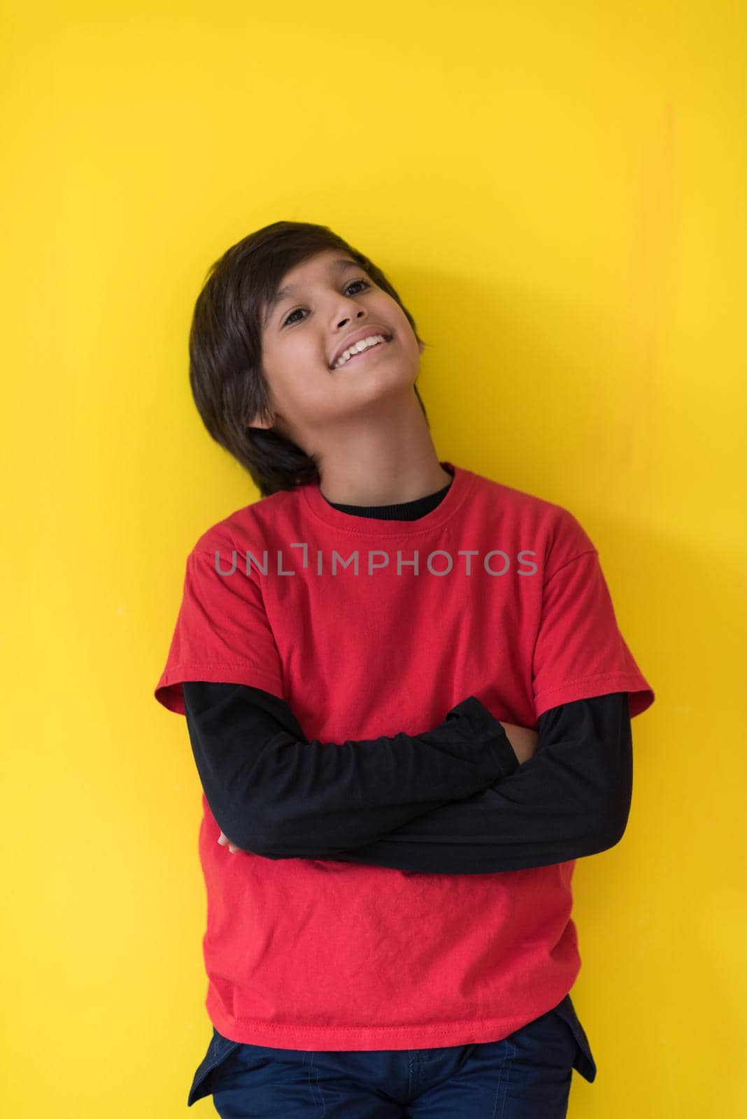 Portrait of a happy young boy in front of colored background