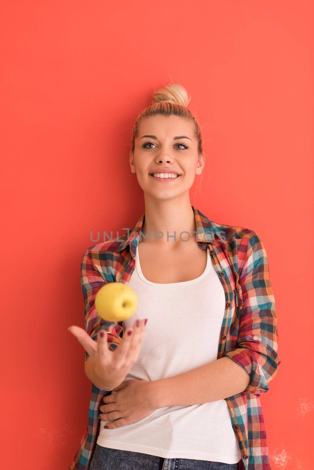 woman over color background plays with apple by dotshock