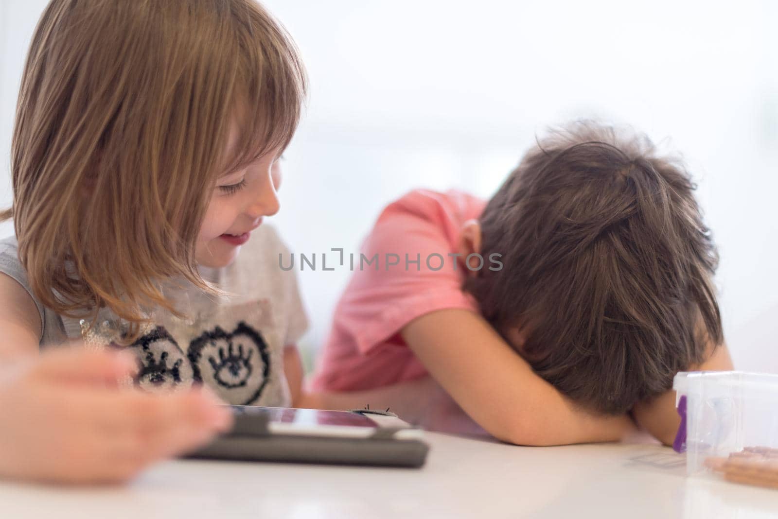 cute little brother and sister having fun at home childrends  playing games on tablet computer