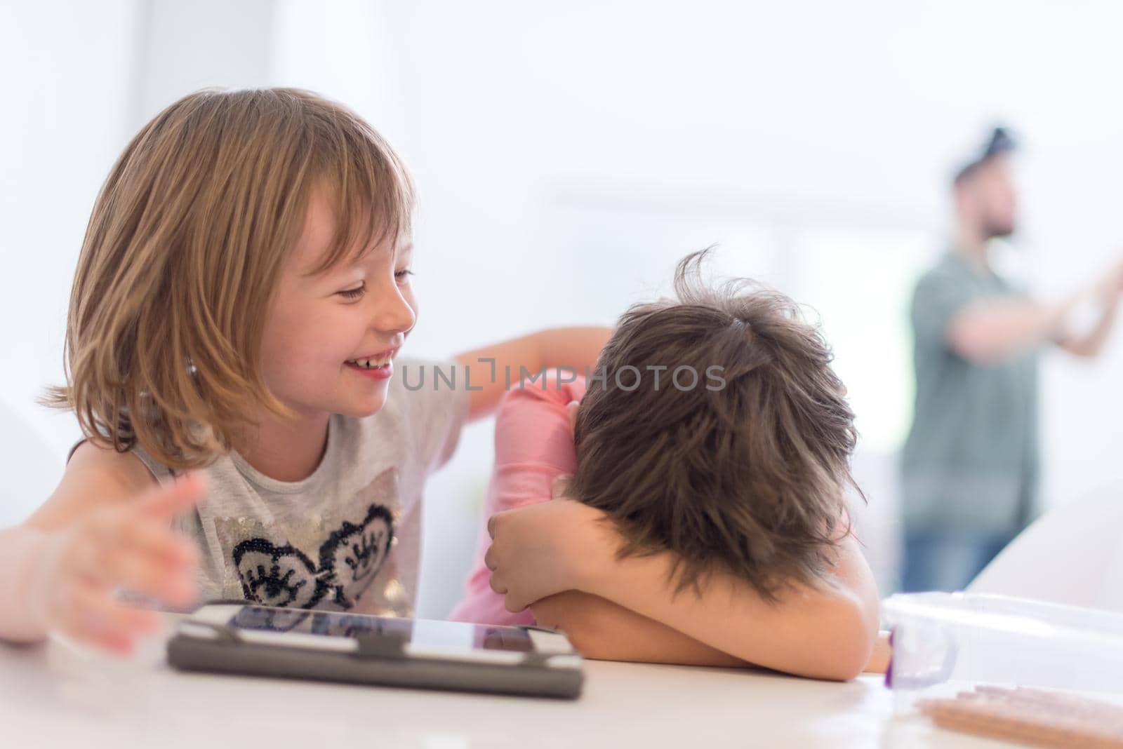 cute little brother and sister having fun at home childrends  playing games on tablet computer