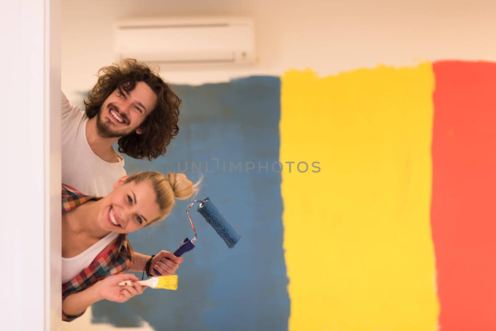 portrait of a couple painting interior wall by dotshock