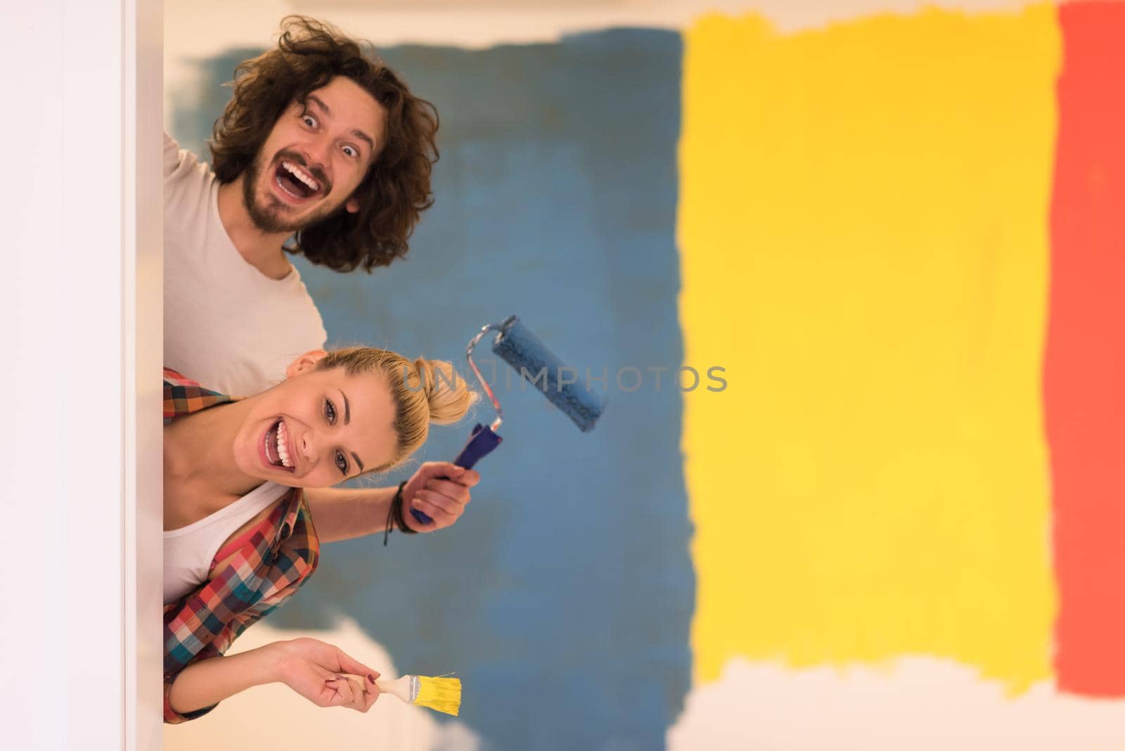 portrait of a couple painting interior wall by dotshock