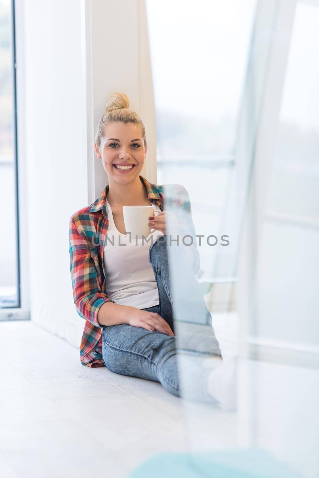 Portrait of a beautiful girl who is sitting on the floor and drinking coffee