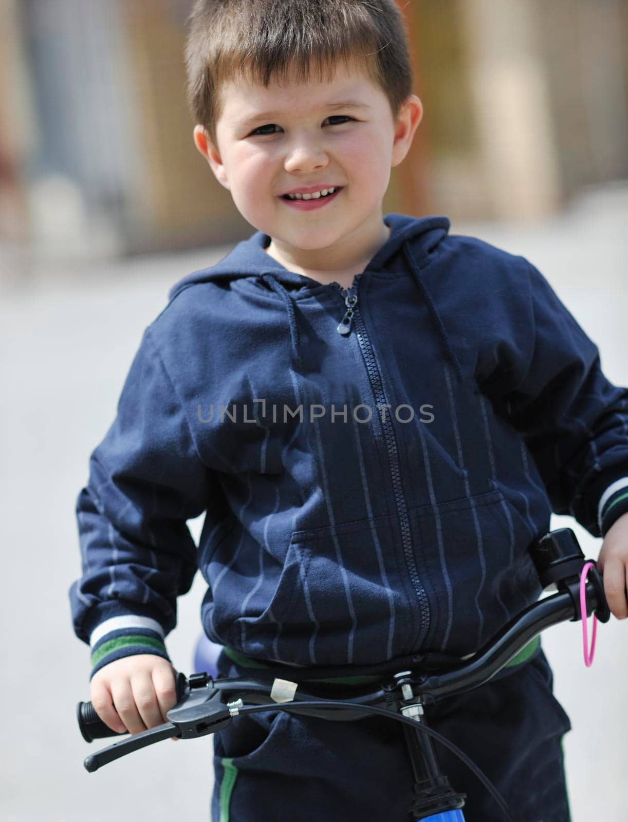 cute little boy outdoor portrait while learning to drive first bicycle 