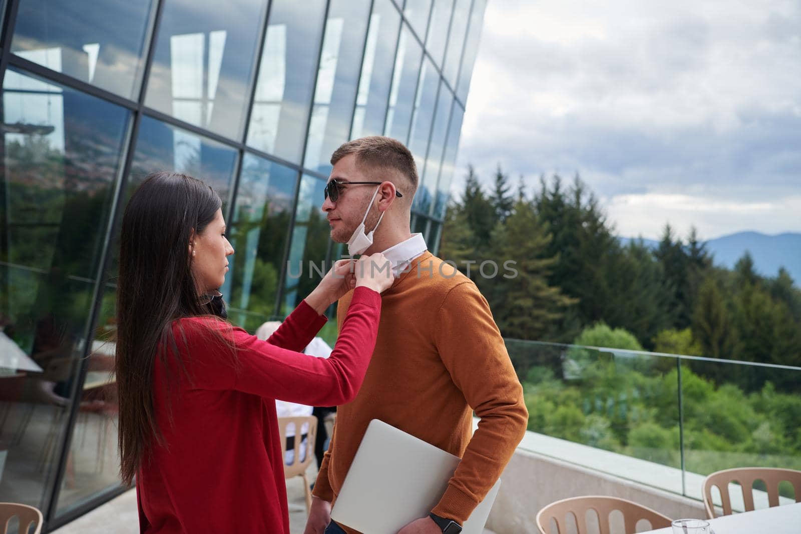 coronavirus outbreak Group of casual business People in outdoor restaurant wearing protective medical mask, business team collaborating and brainstorming business ideas  while working on laptop