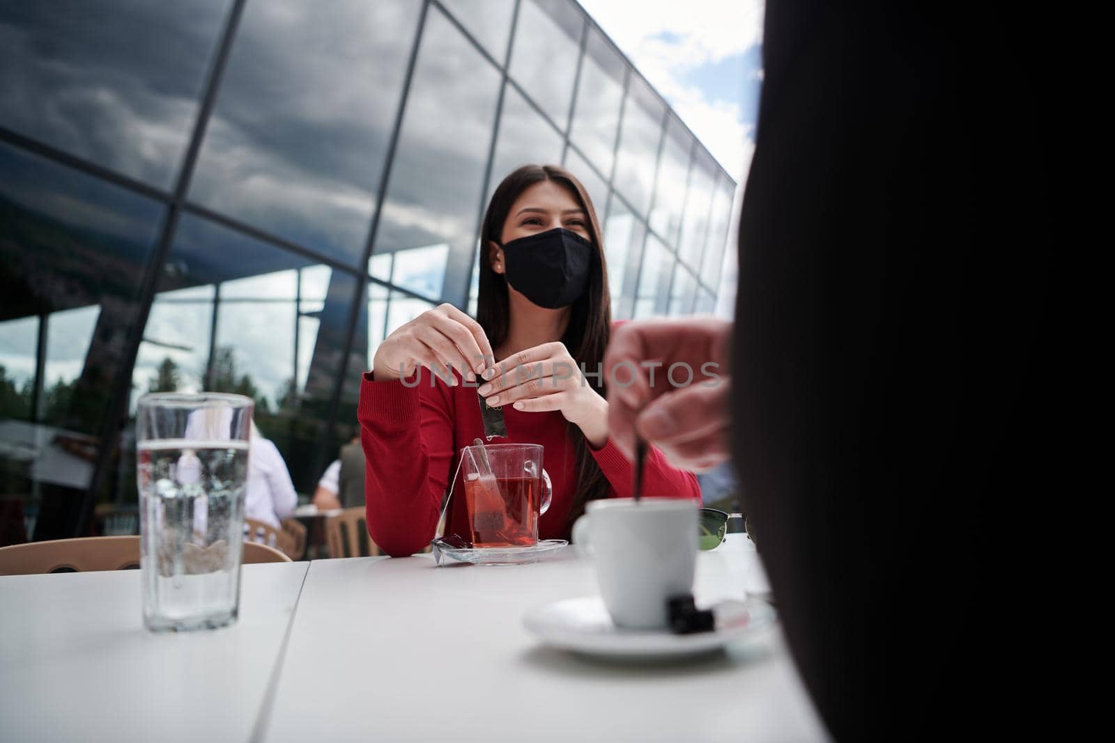 coronavirus outbreak Group of casual business People in outdoor restaurant wearing protective medical mask, business team collaborating and brainstorming business ideas  while working on laptop