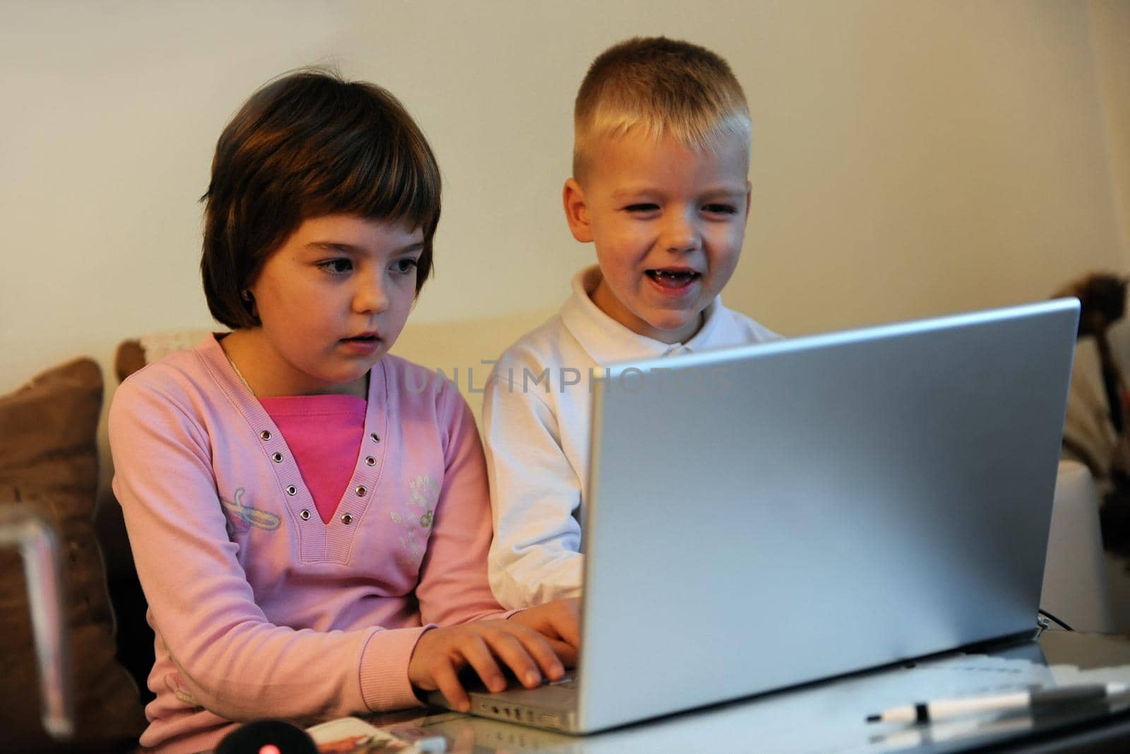 childrens have fun and playing games on laptop computer by dotshock