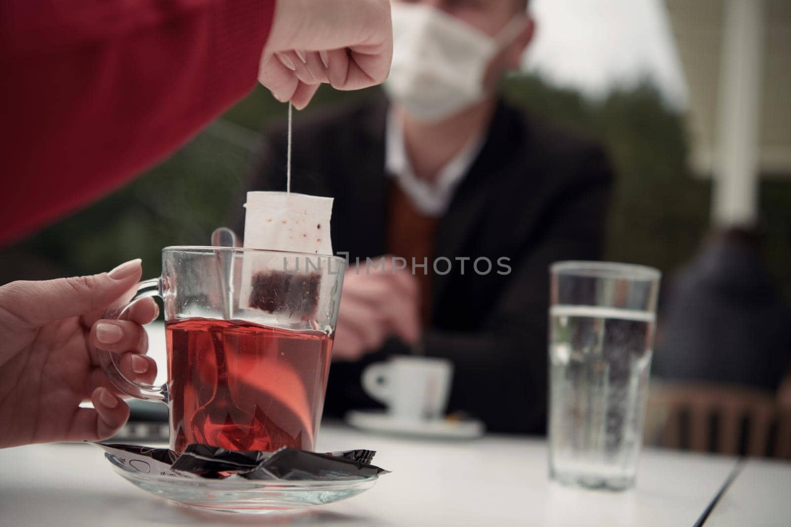 couple with protective medical mask  having coffee break in a restaurant, new normal coronavirus concept