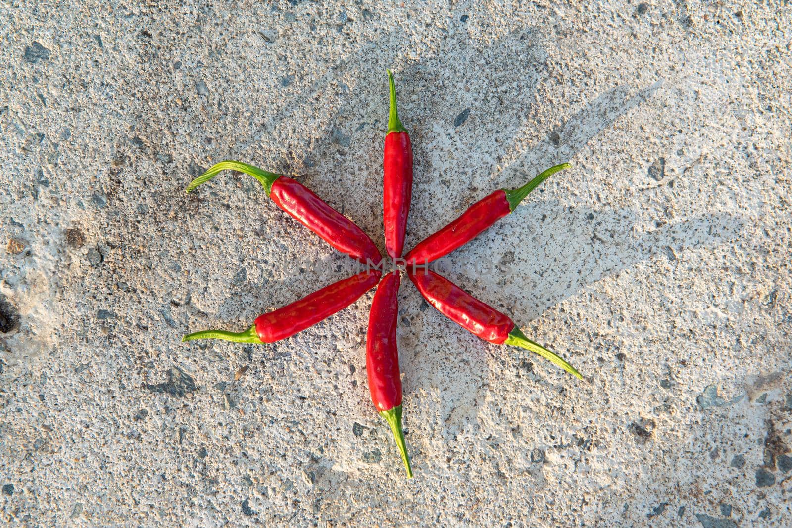 Many small hot red chili peppers close-up, lying on a stone background. Rustic background. Top view, flat lay.