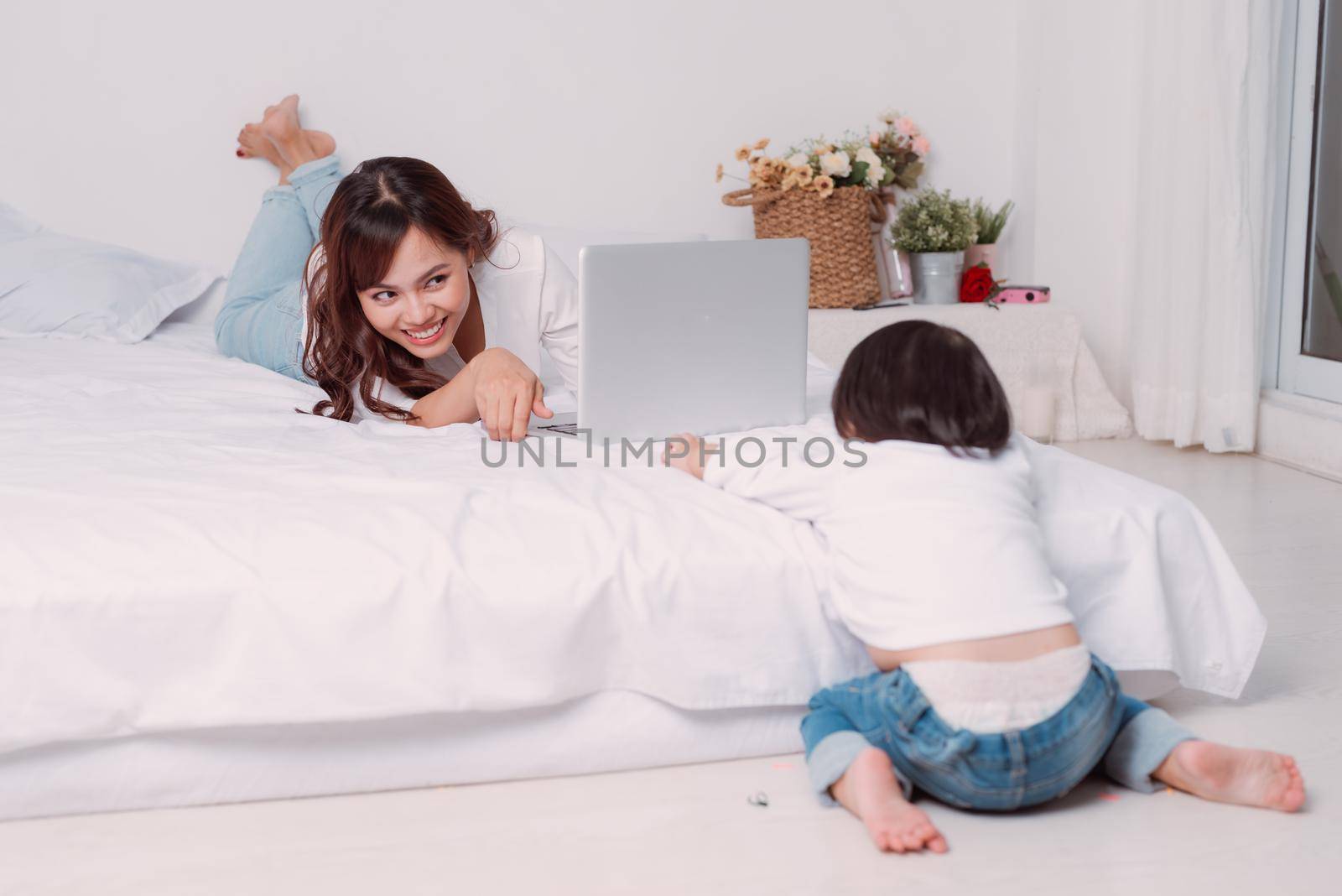 Young adult mother trying to work and spend time with little daughter.