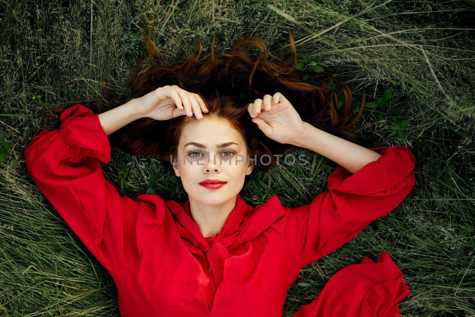 woman in red dress lies on the grass top view freedom by Vichizh