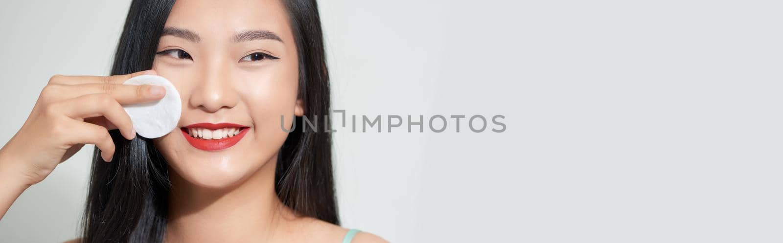 Portrait of a young beautiful woman using sponge, isolated on a white background